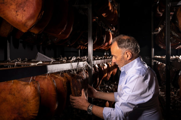 Karl Bernardi controlla la pancetta del prosciutto nella camera di stagionatura della macelleria della città di Brunico