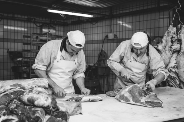 Il mastro macellaio che prepara i prosciutti, la macelleria Bernardi a Brunico